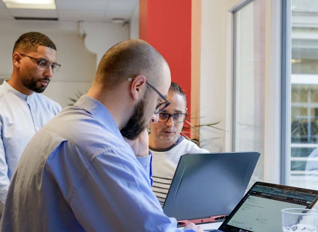 Équipe Uptoo Digital en atelier autour d’un ordinateur